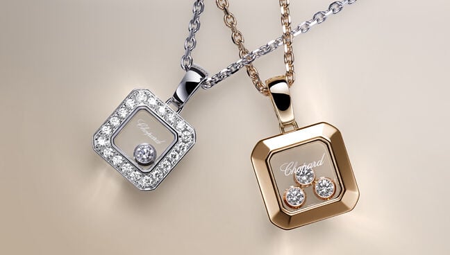 Close-up of Chopard Happy Diamonds square pendant necklaces in white and rose gold with floating diamonds